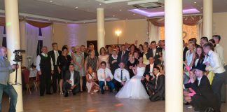 Peruki w akcji: radosne wesele z wodzirejem Karpikiem Wspólne zdjęcie gości weselnych z Parą Młodą