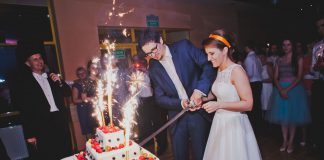 Można zaufać wodzirejowi? Państwo Młodzi przy krojeniu tortu weselnego szablą wodzireja Karpika