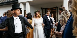 Radość od pierwszego kroku: wesele w Dworze Klembów z wodzirejem Karpikiem Polonez prowadzony przez wodzireja przed salą weselną jako integracyjne rozpoczęcie przyjęcia