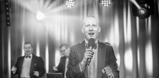 Dlaczego warto zatrudnić wodzireja na imprezę? Wodzirej Piotr Pokój w tle ze swoimi DJami