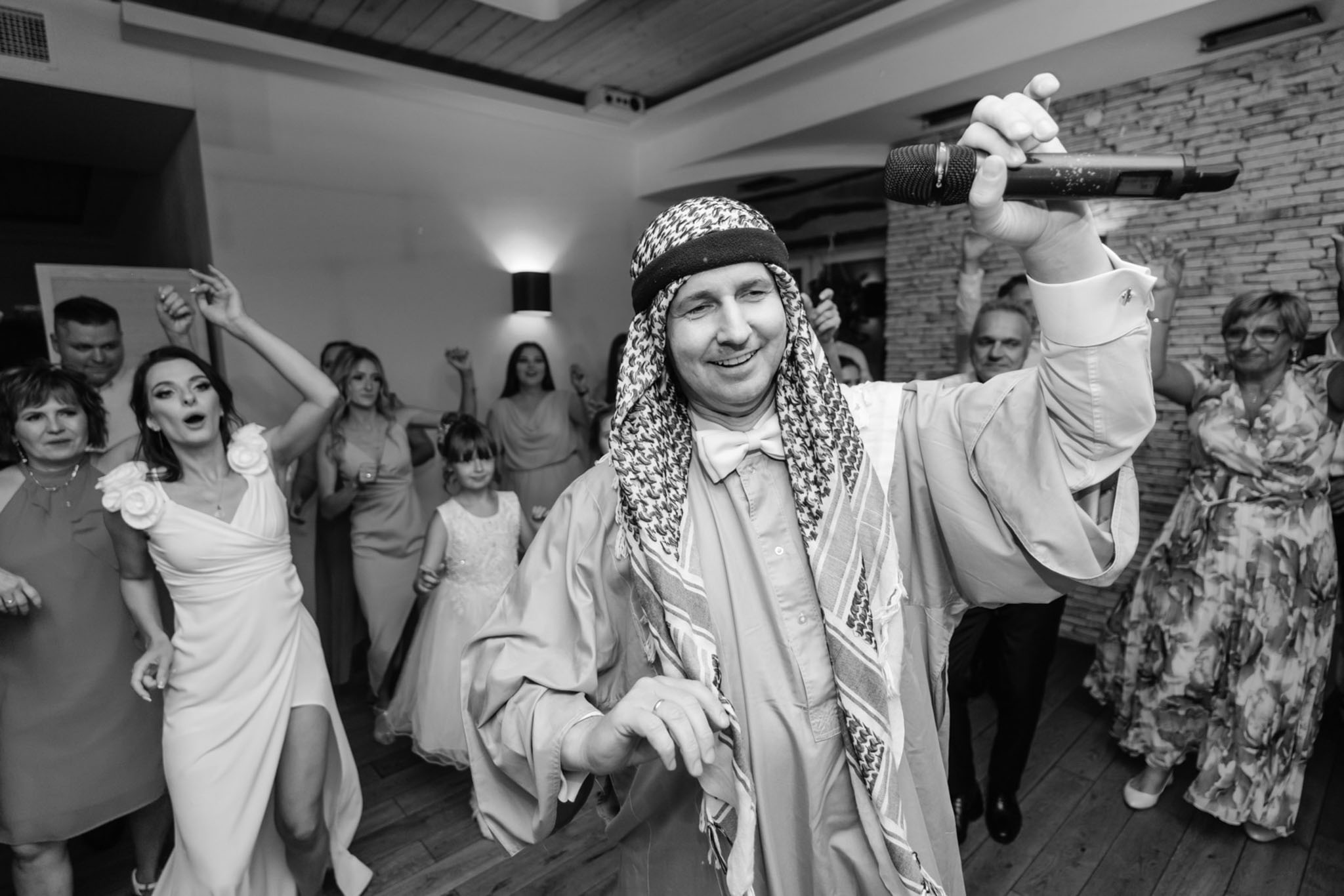 Wodzirej Karpik w stroju araba prowadzący taniec na weselu