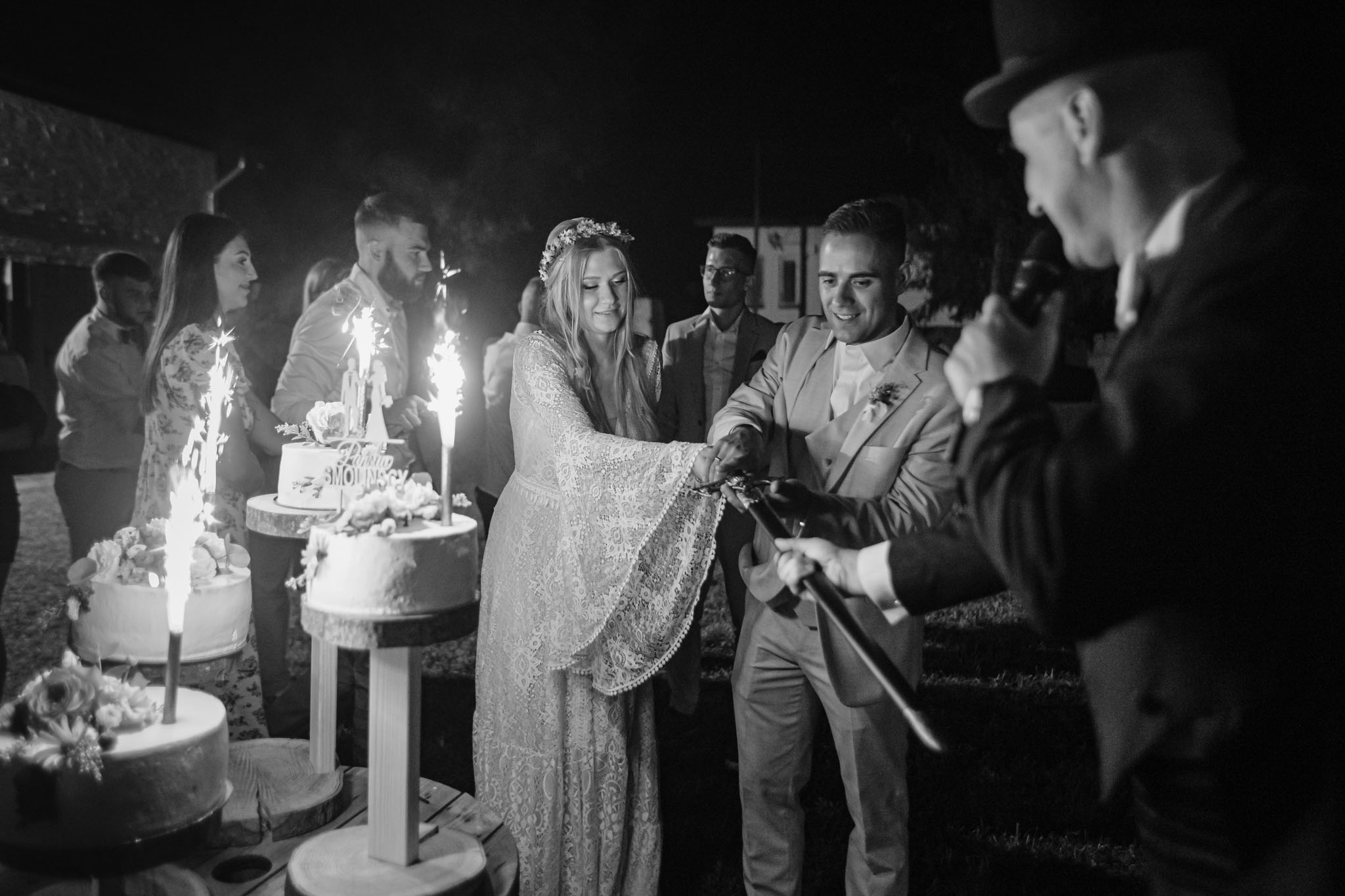 Państwo Młodzi przy krojeniu tortu weselnego szablą wodzireja Karpika