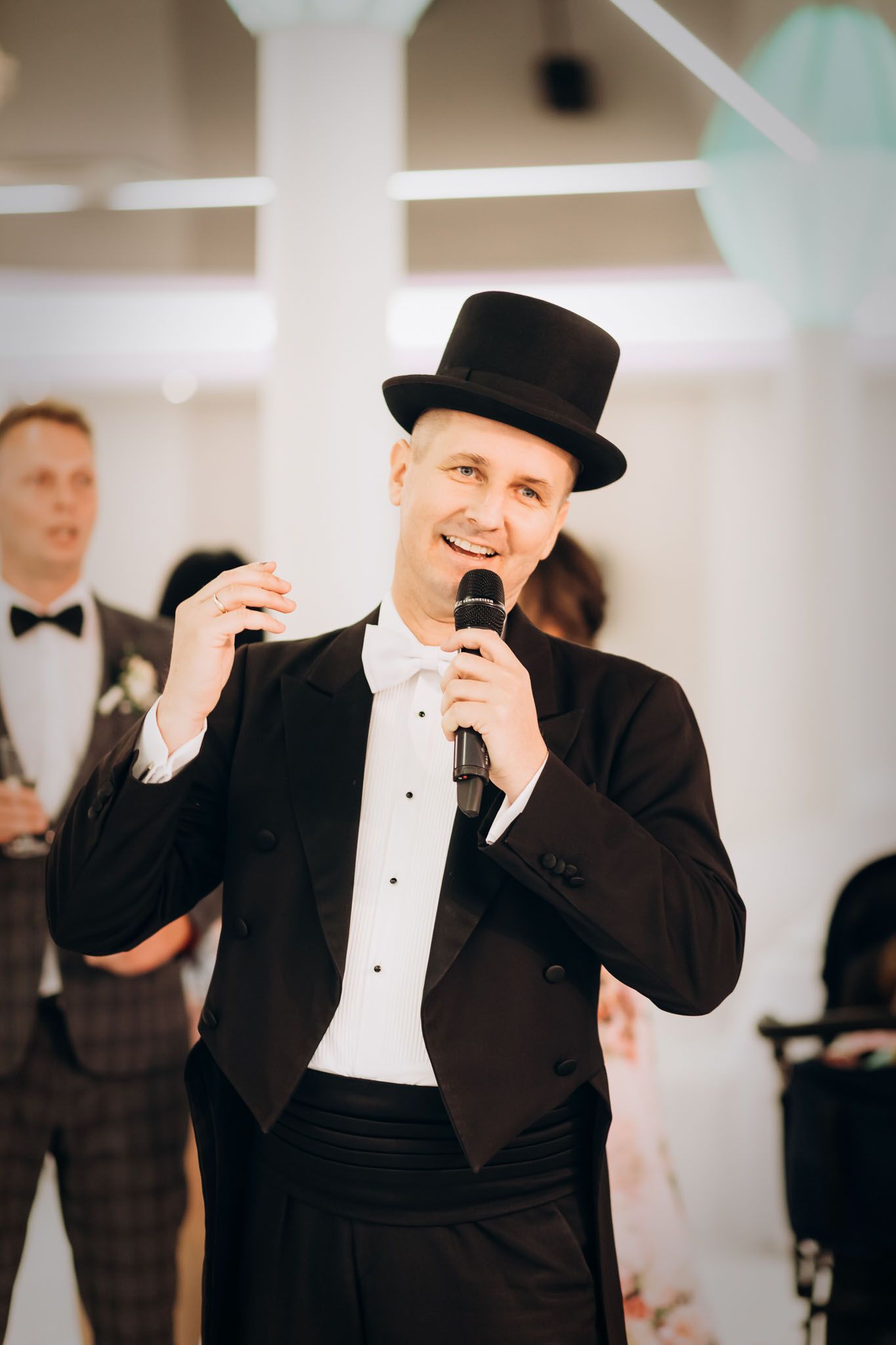Wodzirej Karpik z mikrofonem podczas prowadzenia wesela