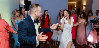 Wodzirej Karpik zaskoczony statuetką na weselu Oli i Sebastiana Para młoda tańczy na weselu z gośćmi.